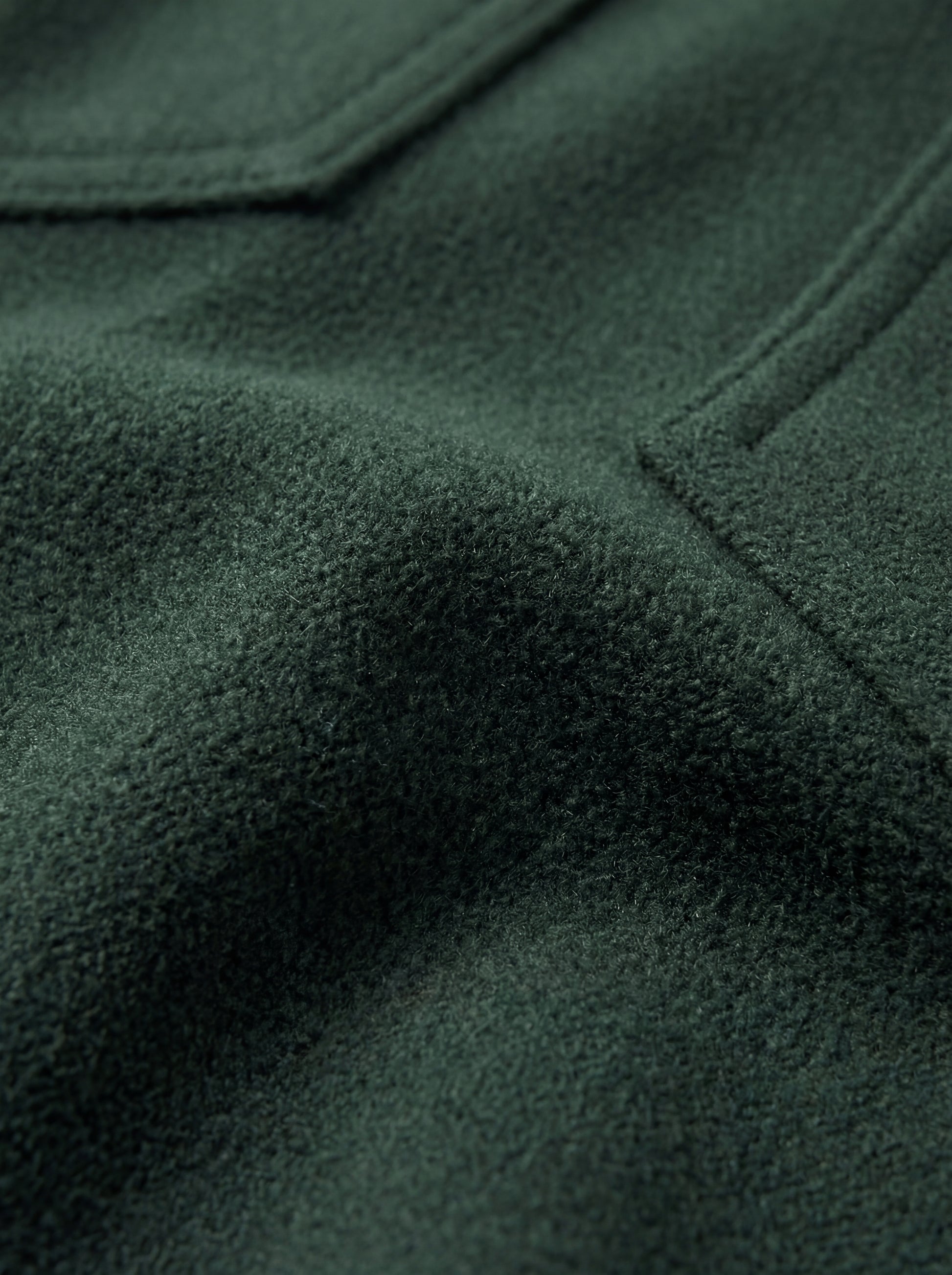 Macro shot of soft green suede texture and silver snap button detail on western shirt. The Liam by Maverick Jacket.