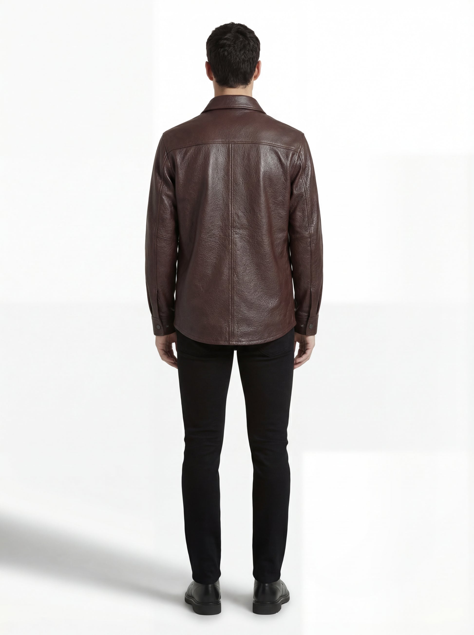 Rear view of male model wearing Maverick Garrison leather overshirt showing tailored shoulder fit and straight hem styling. Maverick Jacket.