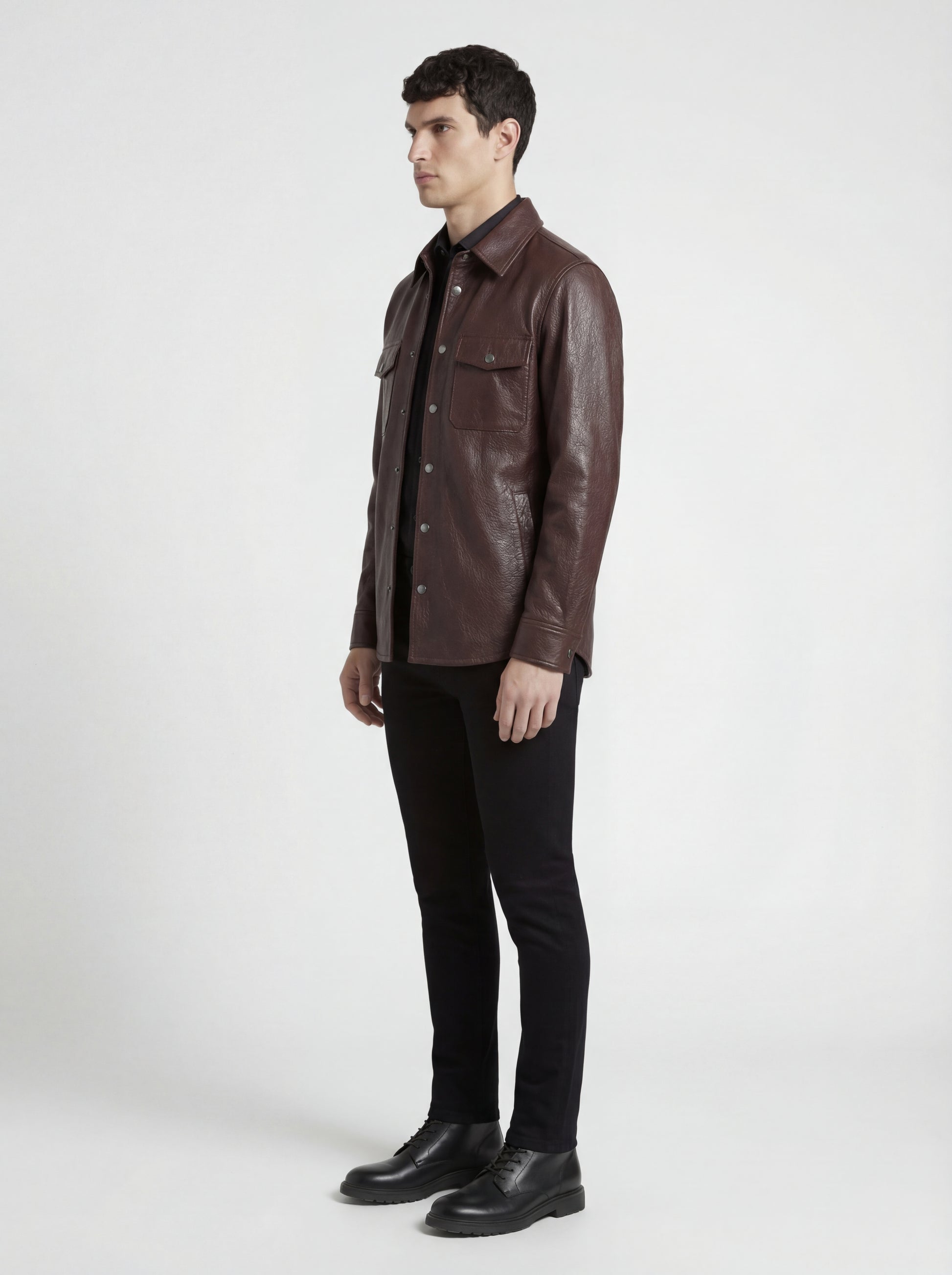 Side profile of Maverick Garrison leather overshirt showing long sleeve cuff structure and straight silhouette. Maverick Jacket.