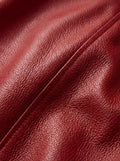 Macro shot of grained red leather texture and tonal stitching detail on bomber jacket. The Isla by Maverick Jacket.