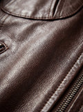Macro shot of pebbled brown leather texture and metal zipper track on bomber jacket. The Sienna by Maverick Jacket.