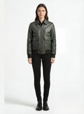 Female model wearing Maverick Verdant green pebbled bomber, regular fit, styled with black button-down shirt and black skinny jeans. Maverick Jacket.