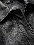 Macro shot of pebbled black leather grain and silver zipper hardware on trucker jacket. The Matrix by Maverick Jacket.