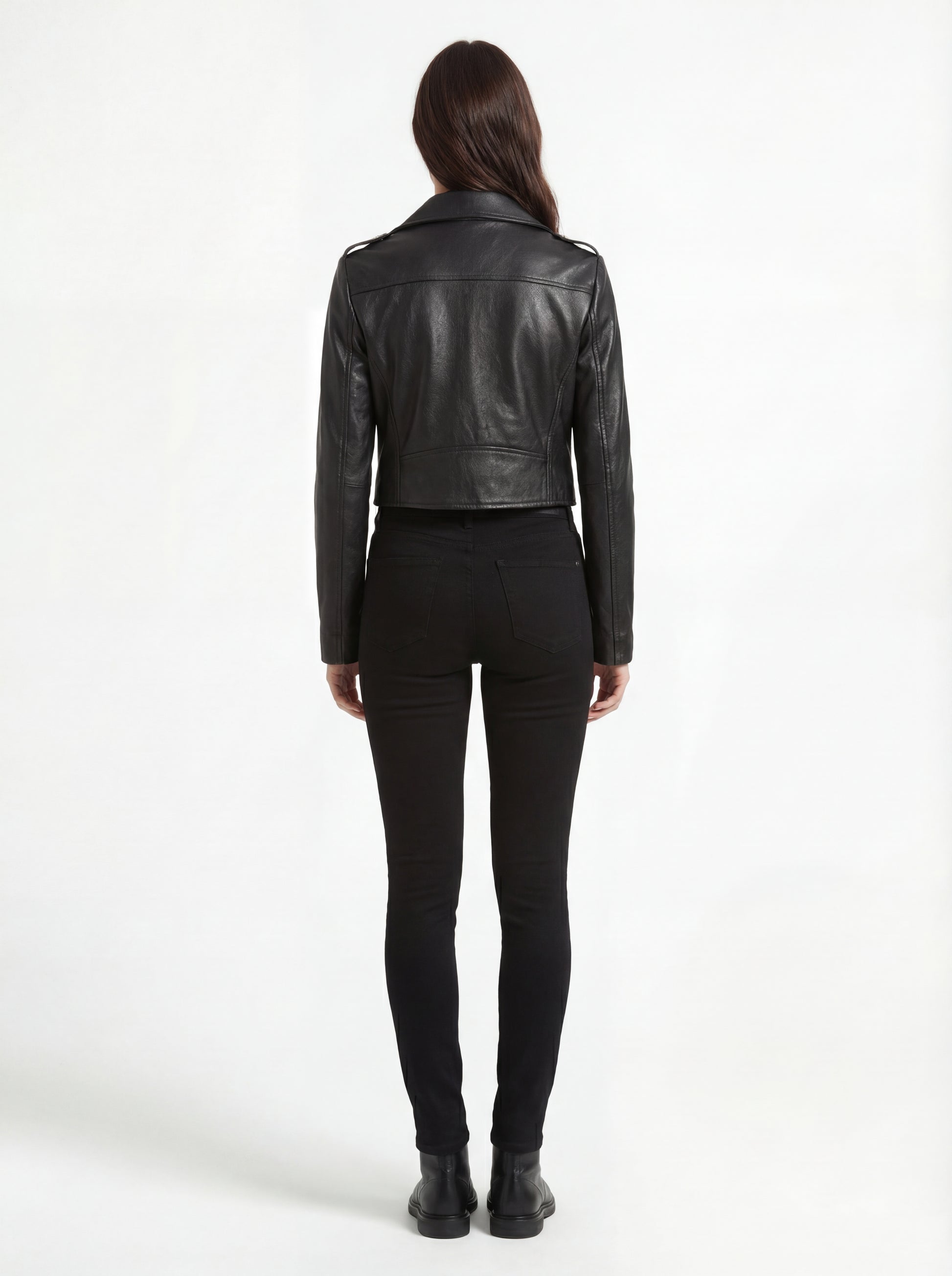 Rear view of female model wearing Maverick Raven black biker jacket showing structured shoulder fit and cropped hem styling. Maverick Jacket.