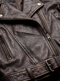 Macro shot of weathered brown leather grain and antique metal zipper hardware on biker jacket. The Zephyr by Maverick Jacket.