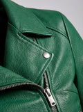 Macro shot of pebbled emerald green leather texture and silver snap button hardware on biker jacket. The Jade by Maverick Jacket.