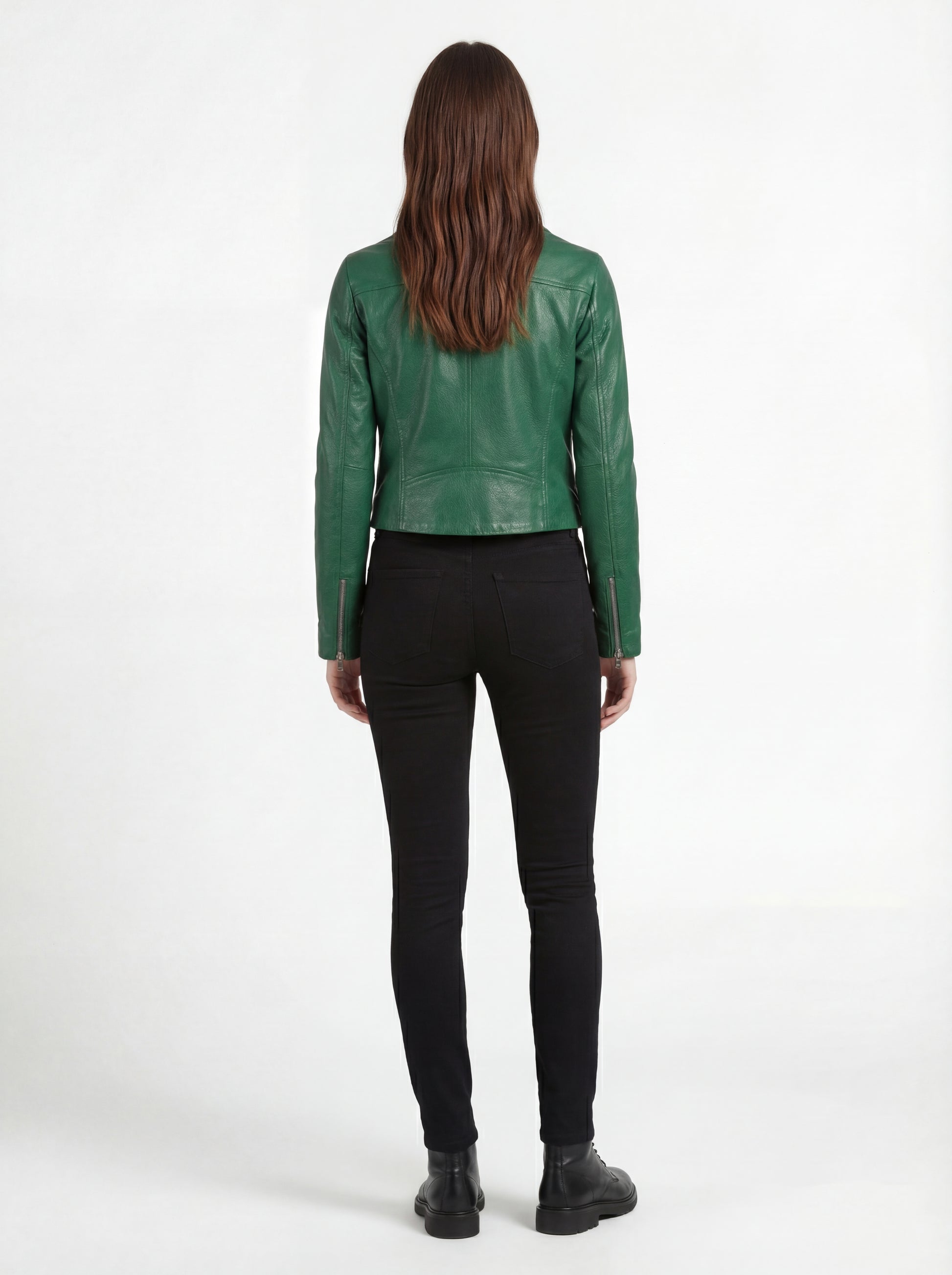 Rear view of female model wearing Maverick Jade emerald green biker jacket showing tailored shoulder fit and cropped hem styling. Maverick Jacket.