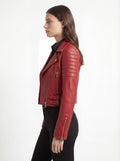 Side profile of Maverick Vixen red biker jacket showing ribbed sleeve quilting and slim cropped silhouette. Maverick Jacket.