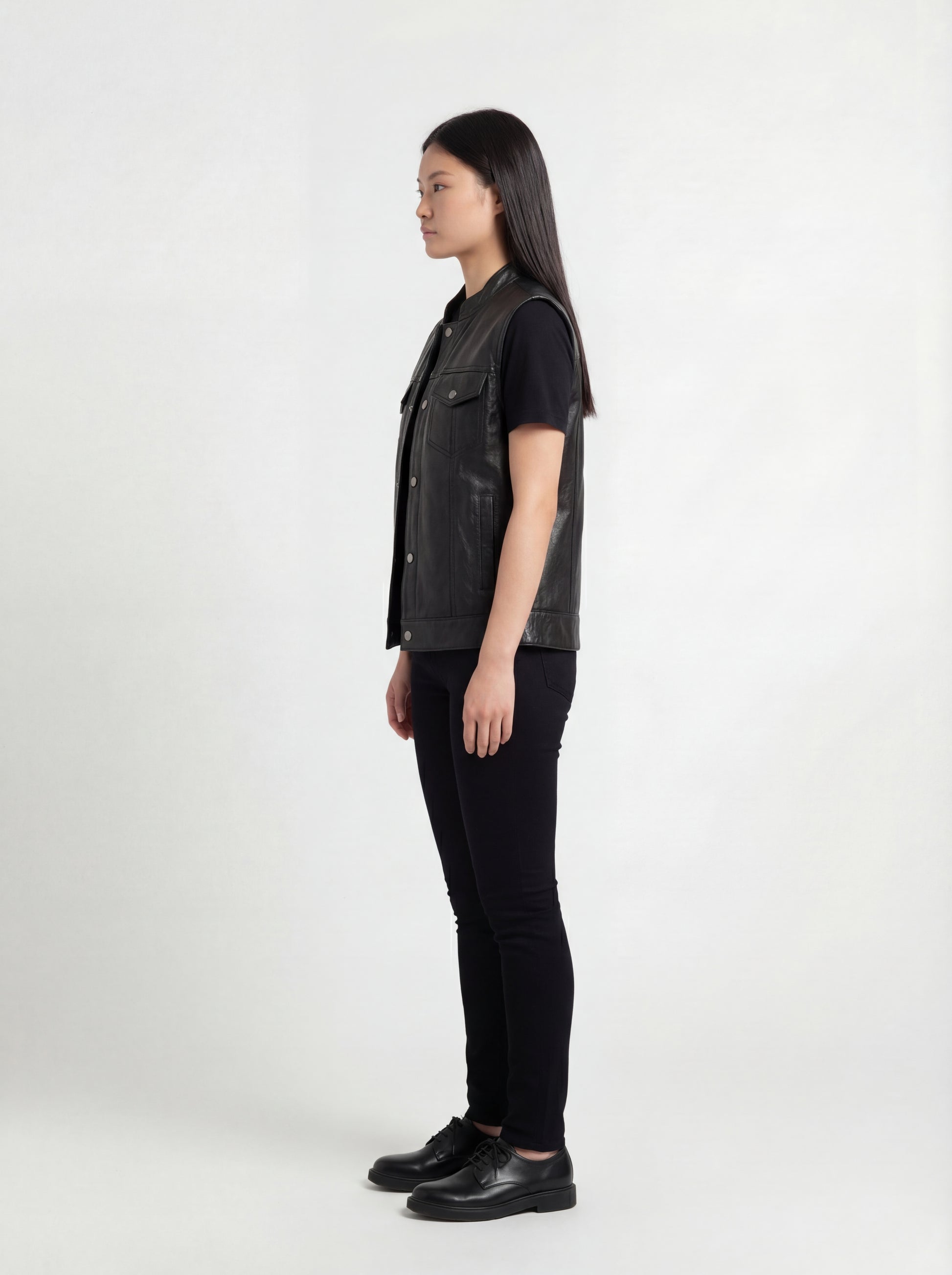 Side profile of Maverick Oakley leather vest showing sleeveless armhole cut and straight hip-length silhouette. Maverick Jacket.