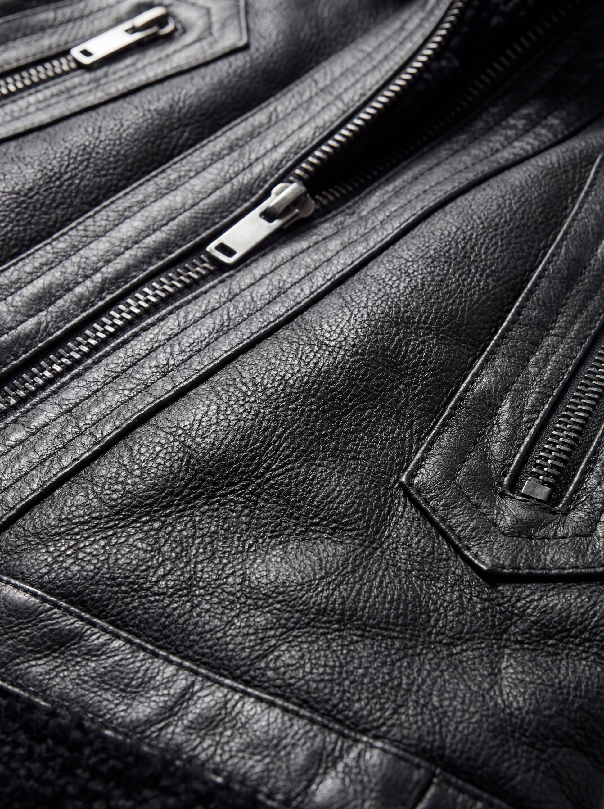 Macro shot of black shearling wool texture and silver metal zipper details on vest. The Aves by Maverick Jacket.