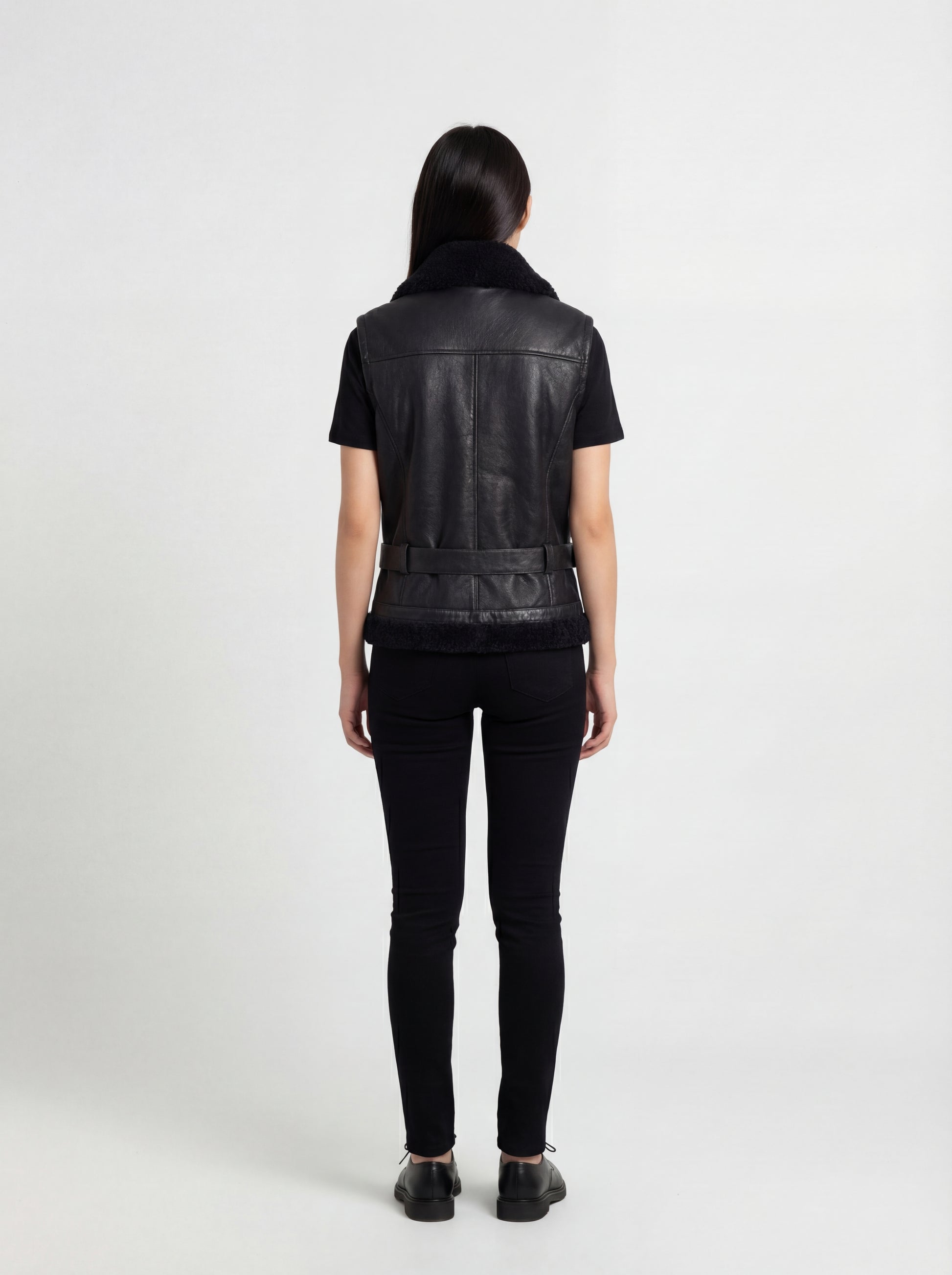 Rear view of female model wearing Maverick Aves shearling vest showing fitted back silhouette and panel construction. Maverick Jacket.