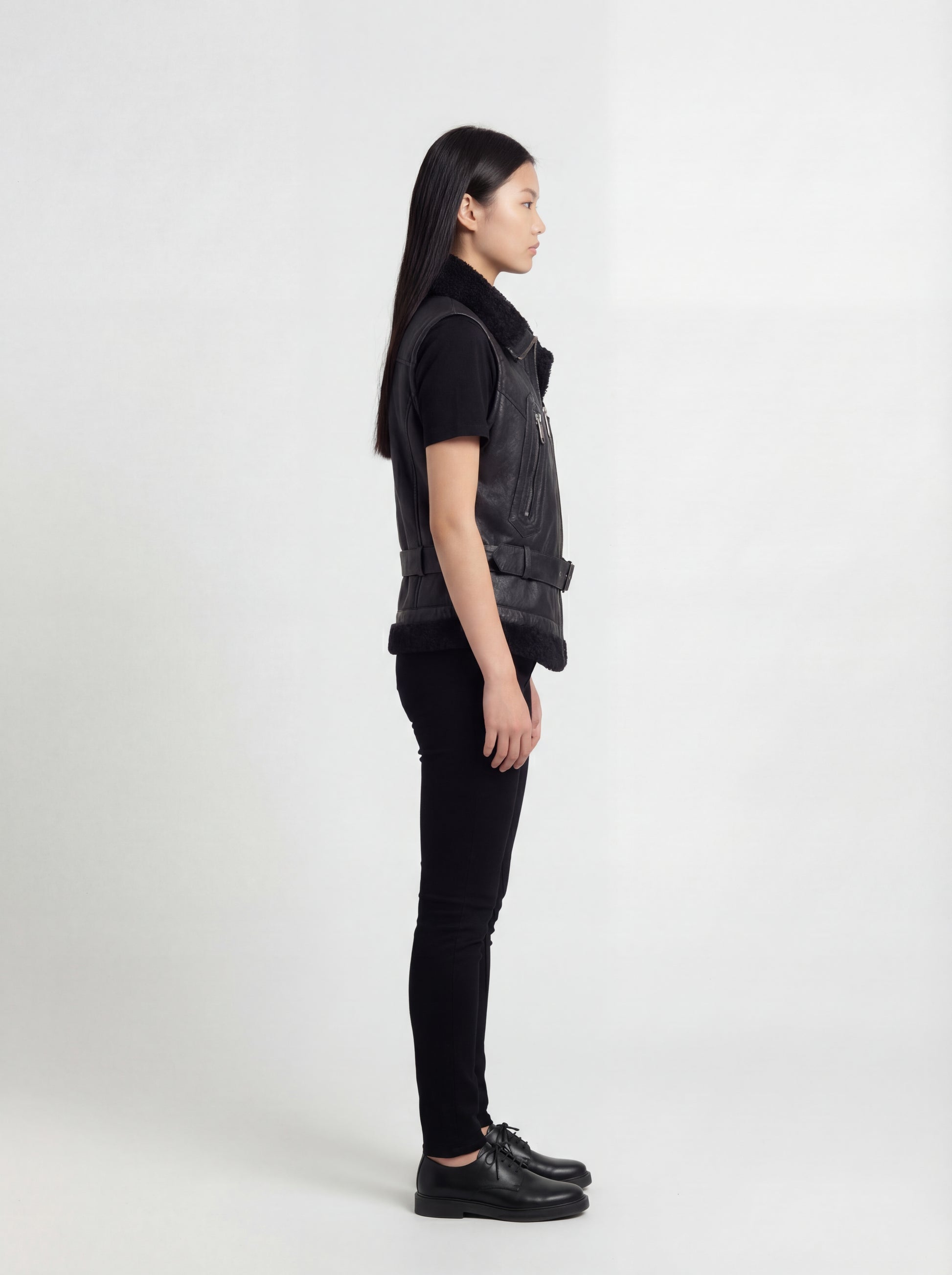 Side profile of Maverick Aves shearling vest showing sleeveless cut and belted waist adjustment. Maverick Jacket.