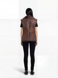 Rear view of female model wearing Maverick Freya leather vest showing fur collar drape and straight back styling. Maverick Jacket.