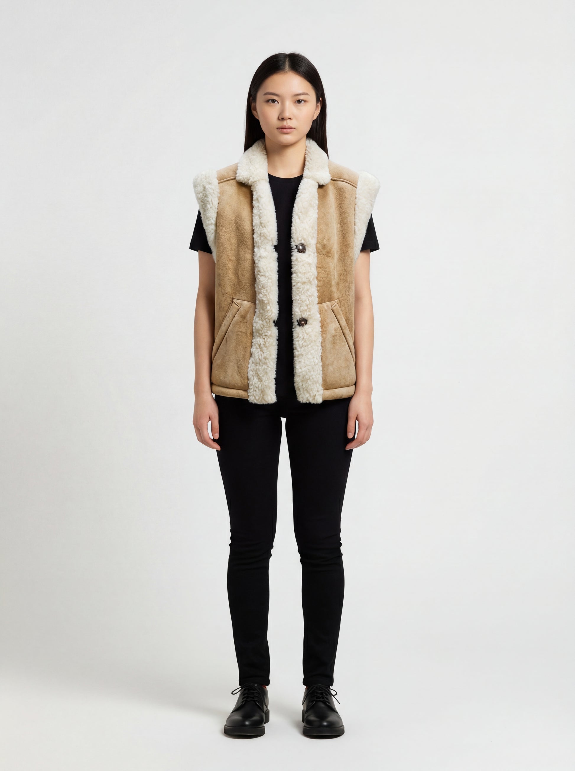 Female model wearing Maverick Vail shearling vest, relaxed fit, styled with black skinny jeans and black leather derby shoes. Maverick Jacket.