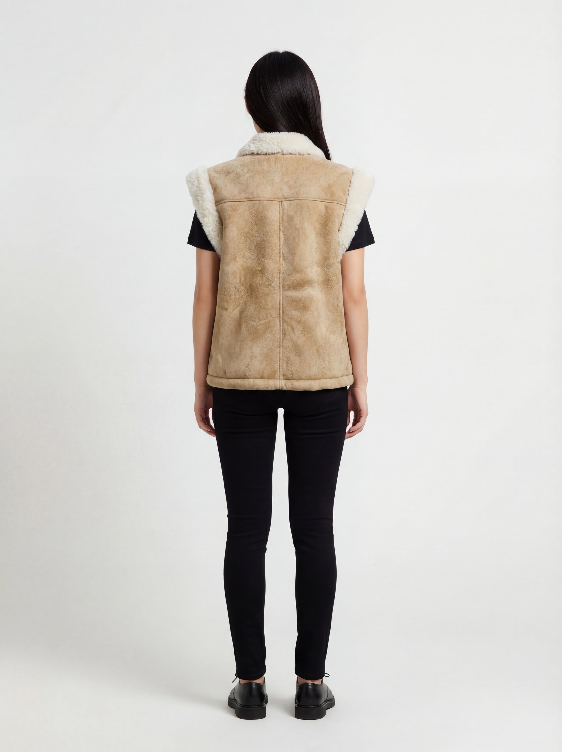 Rear view of female model wearing Maverick Vail shearling vest showing structured shoulder fit and panelled back styling. Maverick Jacket.