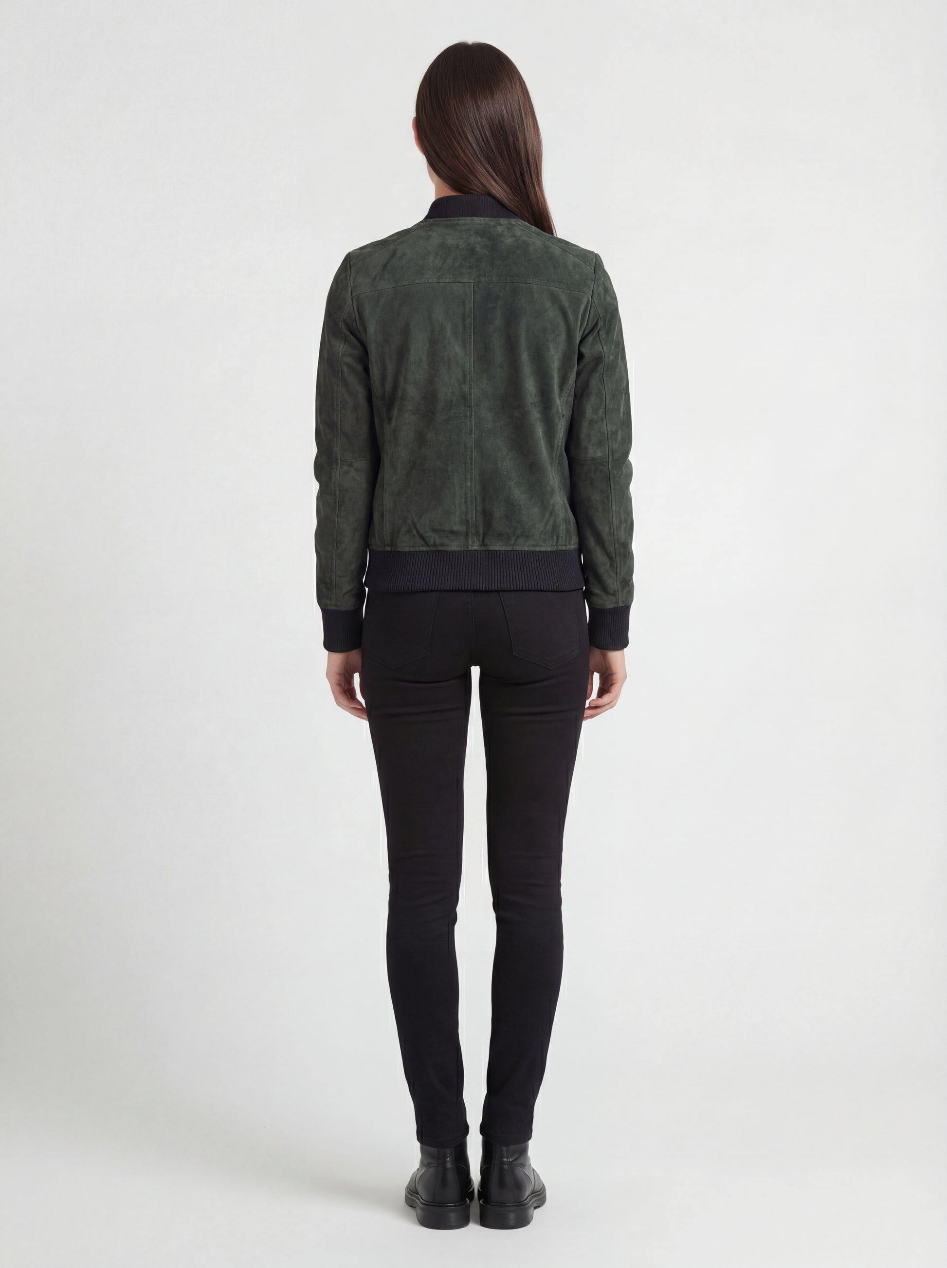 Rear view of female model wearing Maverick Willow suede bomber jacket showing structured shoulder fit and black ribbed hem. Maverick Jacket.