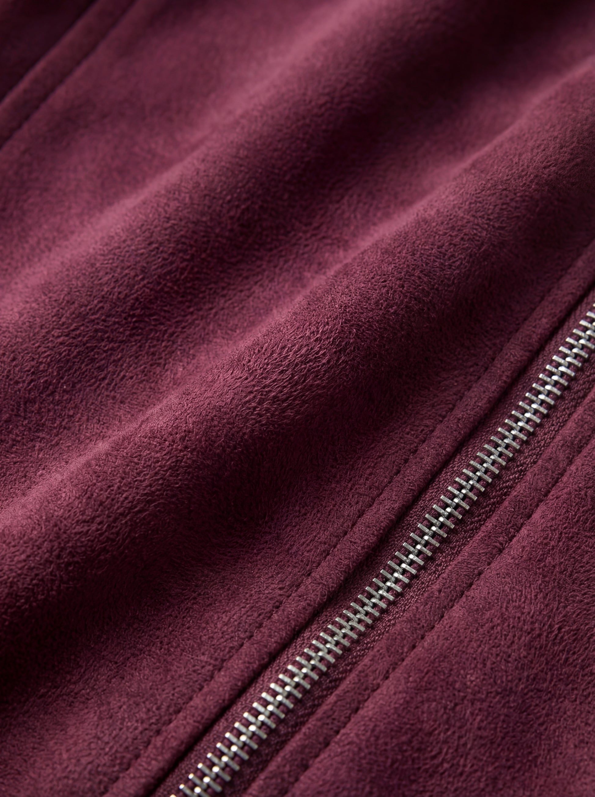 Macro shot of soft plum purple suede texture and heavy-duty silver zipper hardware on biker jacket. The Amethyst by Maverick Jacket.
