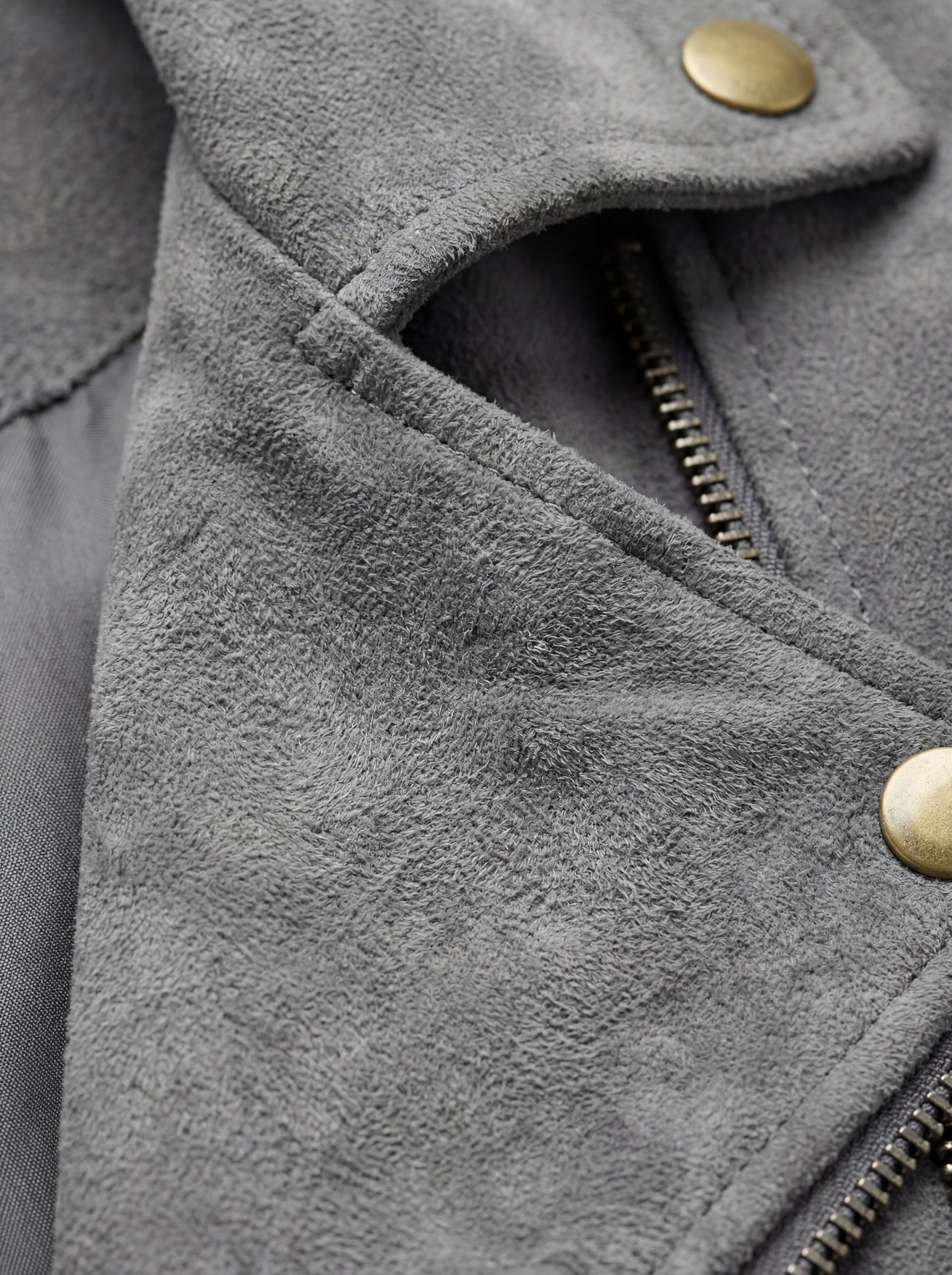Macro shot of soft grey suede texture and gold snap button hardware on biker jacket. Maverick Jacket Maverick Luna.