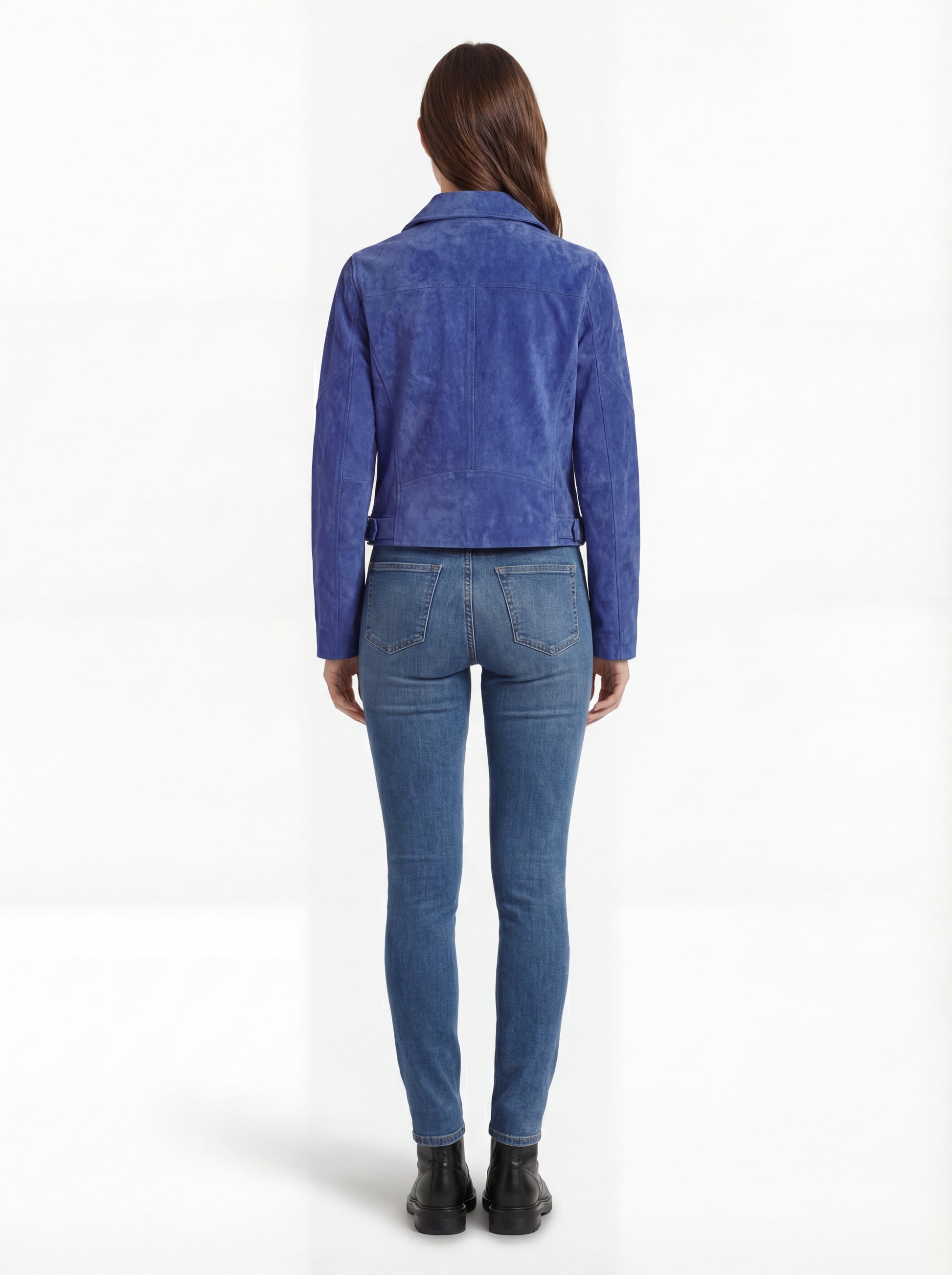 Rear view of female model wearing Maverick Sapphire suede biker jacket showing fitted shoulder structure and clean back styling. Maverick Jacket.