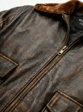 Macro shot of heavily distressed brown leather texture and antique brass zipper on aviator jacket. The Corsair by Maverick Jacket.