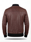 Rear view of brown leather bomber jacket showing vertical center seam and black ribbed knit waistband. The Stratus by Maverick Jacket.