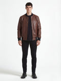 Male model wearing Maverick Vector brown leather bomber jacket, casual fit, styled with black crew neck t-shirt and black skinny jeans. Maverick Jacket.