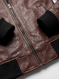 Macro shot of pebbled brown leather texture and black ribbed knit cuff on bomber jacket. The Stratus by Maverick Jacket.