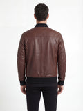 Rear view of male model wearing Maverick Vector brown leather bomber jacket showing fitted shoulder silhouette and ribbed hem styling. Maverick Jacket.