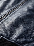 Macro shot of pebbled navy blue leather texture and silver zipper teeth on MA-1 bomber jacket. The Stratus by Maverick Jacket.