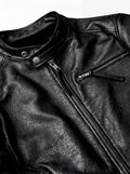 Macro shot of textured black leather grain and silver zipper hardware on cafe racer jacket. The Zenith by Maverick Jacket.