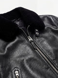 Macro shot of pebbled black leather texture and plush fur collar detail on Flight Jacket. The Phantom by Maverick Jacket.