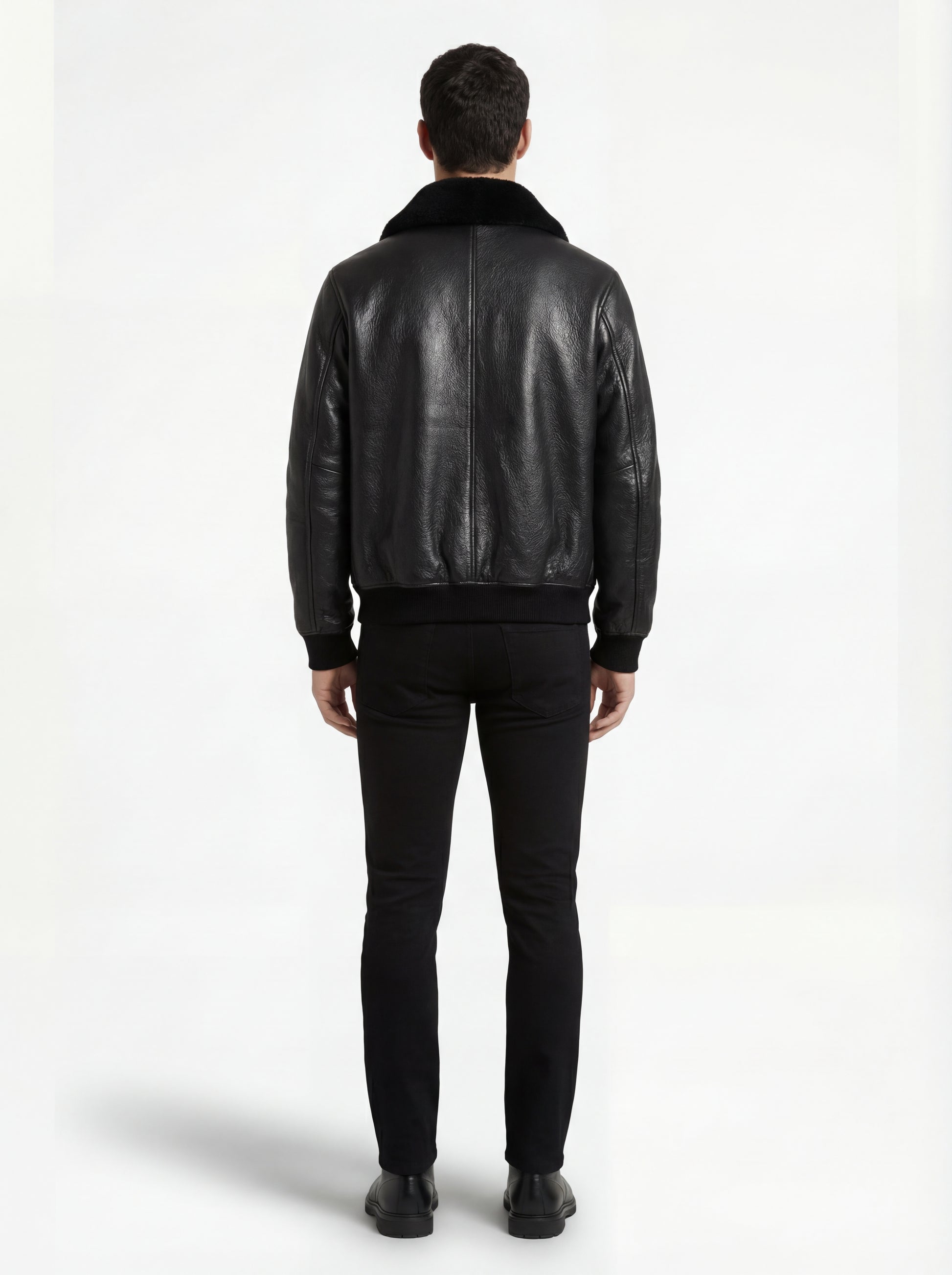 Rear view of male model wearing Maverick Phantom Black Leather Flight Jacket showing broad shoulder fit and shearling hem detail. Maverick Jacket.