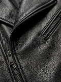 Macro shot of black pebbled leather grain texture and silver diagonal zipper pocket on biker jacket. The Night Rider by Maverick Jacket.