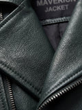 Macro shot of dark green pebbled leather grain texture and silver zipper hardware detail on biker jacket. The Rogue by Maverick Jacket.