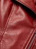 Macro shot of pebbled red leather texture and silver metal zipper teeth on peplum coat. Maverick Valencia.