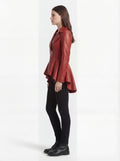 Side profile of Maverick Valencia peplum coat showing long sleeve structure and high-low hem silhouette. Maverick Valencia.