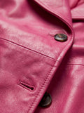 Macro shot of smooth pink leather texture and tonal button hardware on trench coat. The Eira is Maverick Jacket.