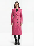 Female model wearing Maverick Eira pink leather trench coat, tailored fit, styled over a white blouse with white wide-leg trousers. Maverick Jacket.
