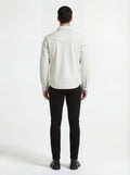 Rear view of male model wearing Maverick Tiernan off-white leather western shirt showing tailored shoulder fit and western yoke styling. Maverick Jacket.