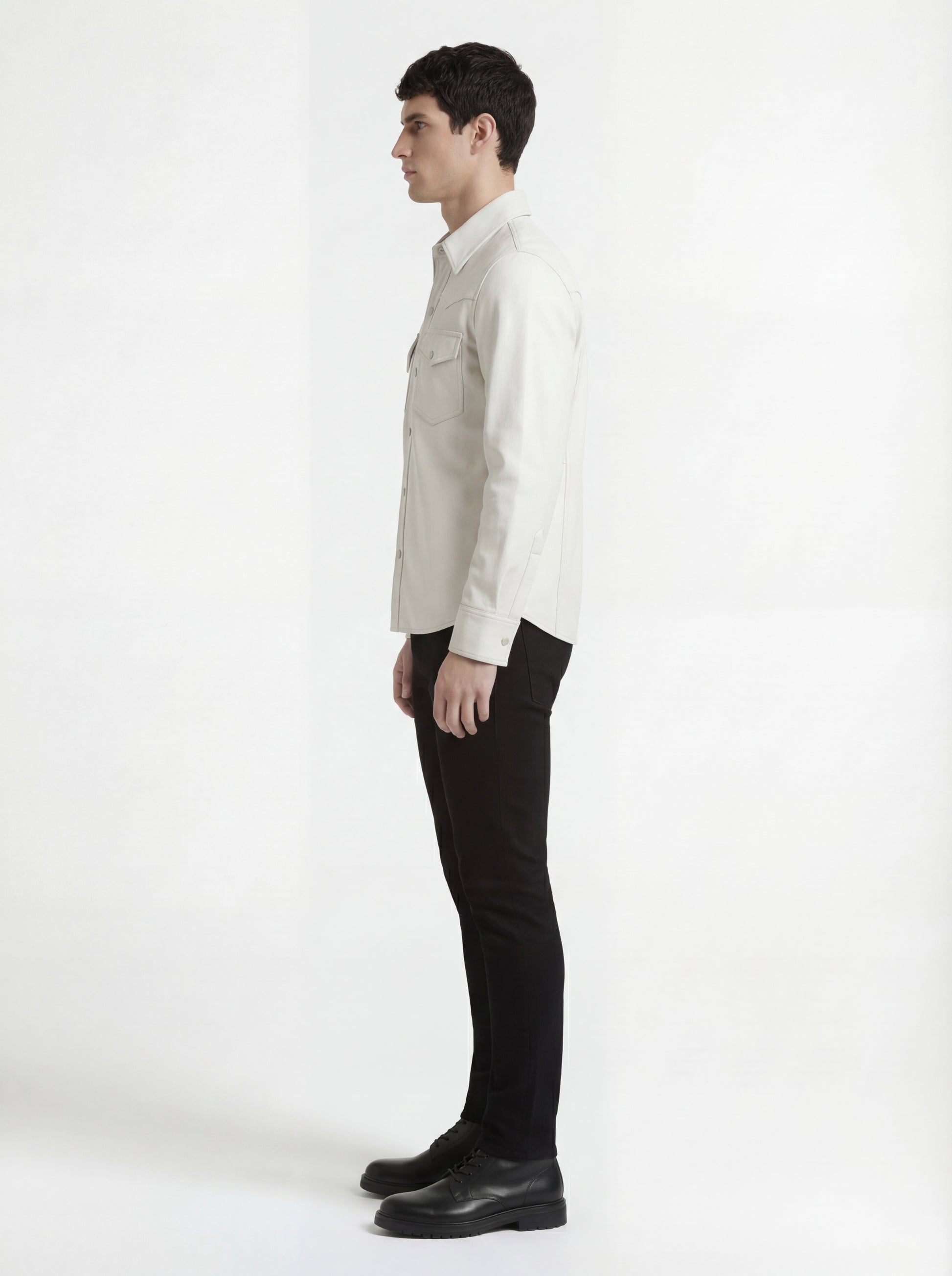 Side profile of Maverick Tiernan off-white leather western shirt showing long sleeve cuff structure and straight silhouette. Maverick Jacket.