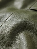 Macro shot of grained olive green leather texture and shoulder stitching detail on zip shirt. The Killian by Maverick Jacket.