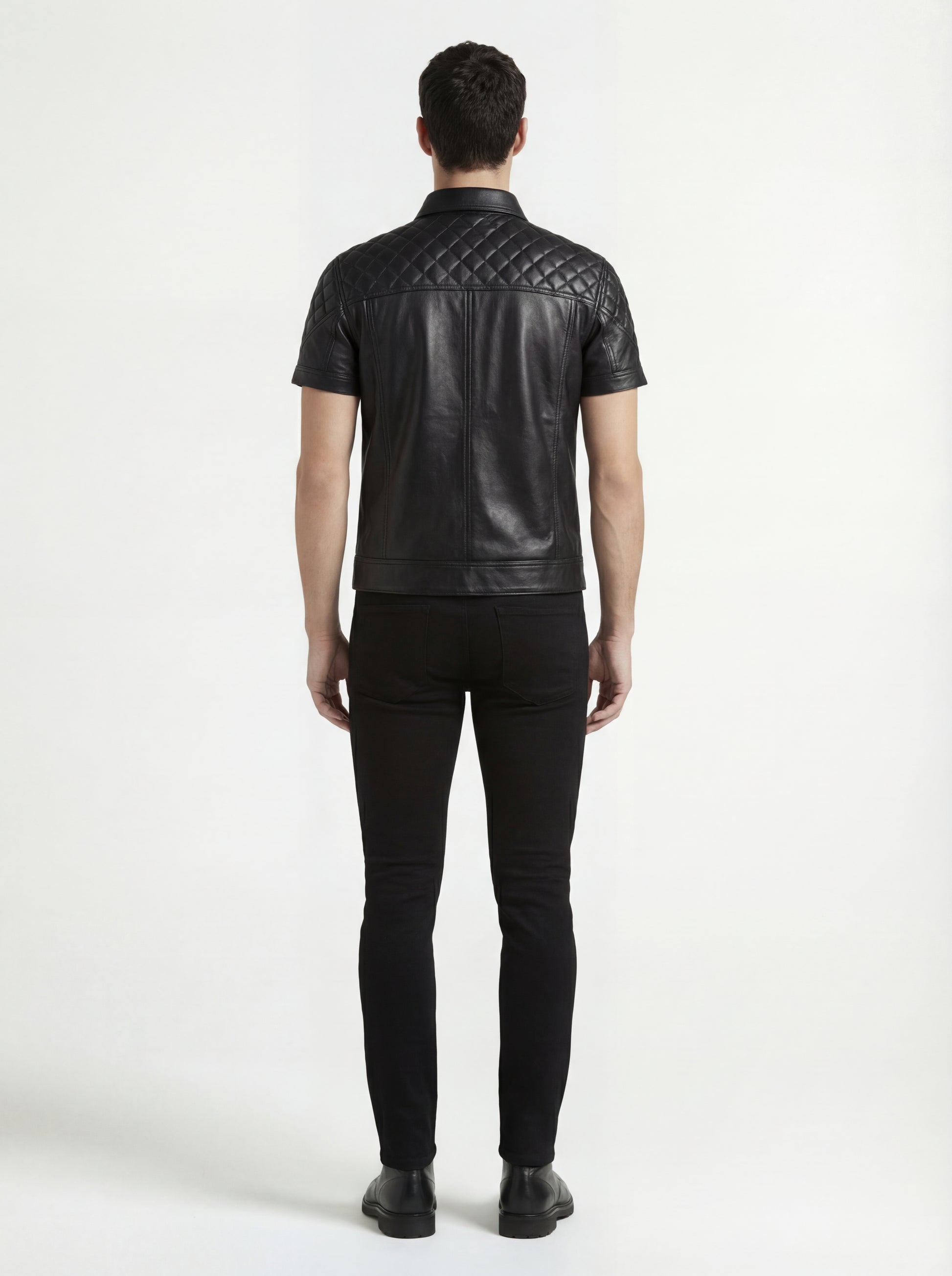 Rear view of male model wearing Maverick Mason short-sleeve leather shirt showing quilted yoke fit and straight hem styling. Maverick Jacket.
