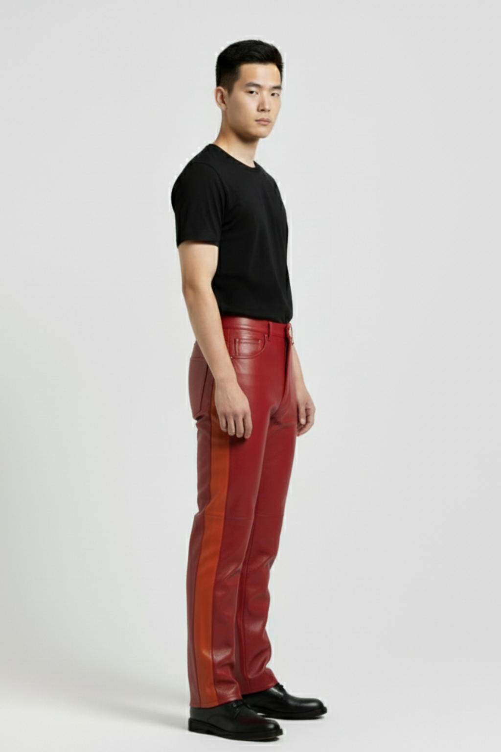 Side profile of male model wearing Maverick Jagger two-tone leather racing pants showing contrasting side stripe and straight silhouette. Maverick Jacket.