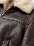 Macro shot of dark brown pebbled leather grain and cream shearling collar texture on aviator jacket. The Nomad by Maverick Jacket.