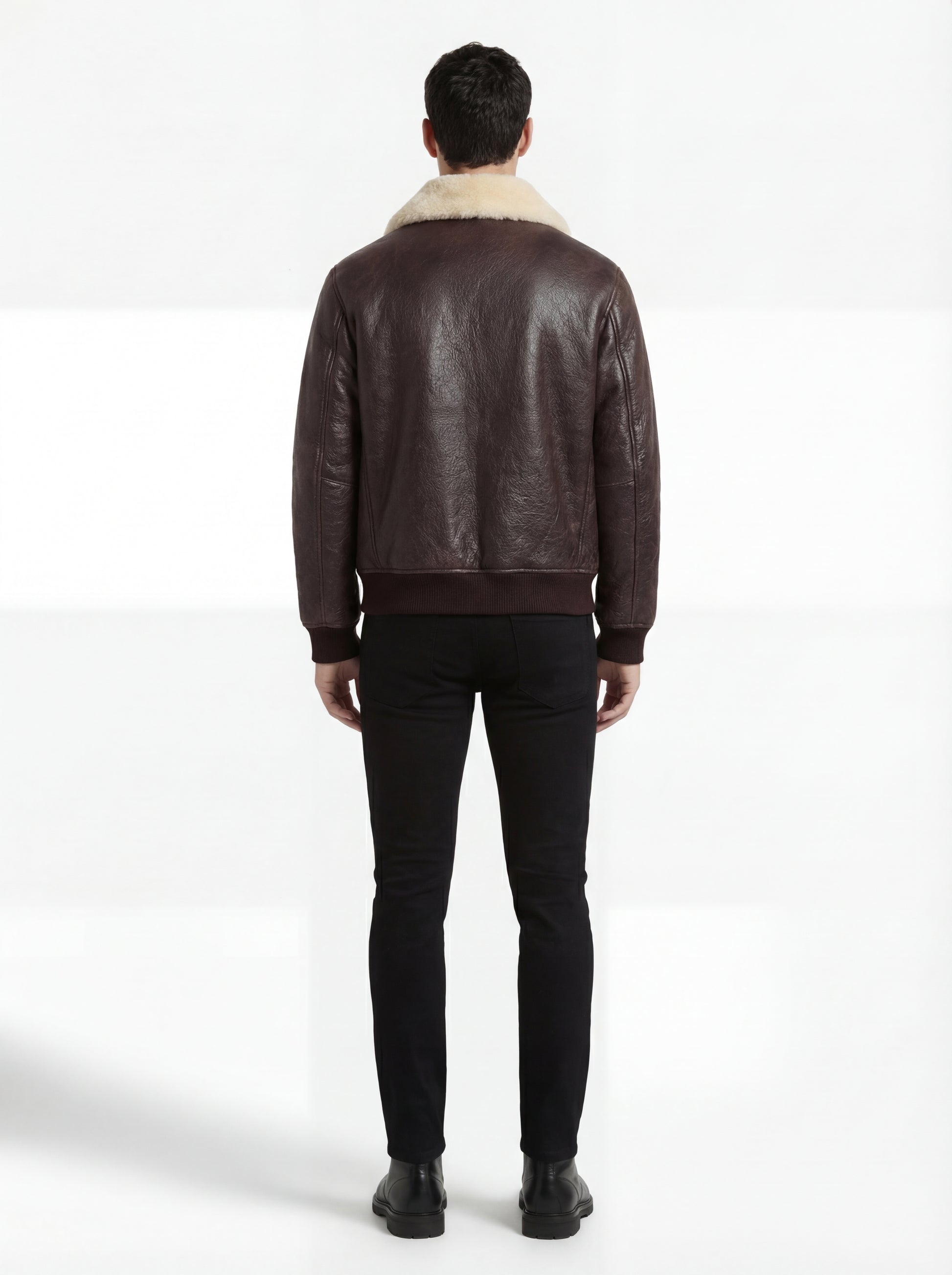 Rear view of male model wearing Maverick Nomad aviator jacket showing broad shoulder fit and ribbed hem drape. Maverick Jacket.