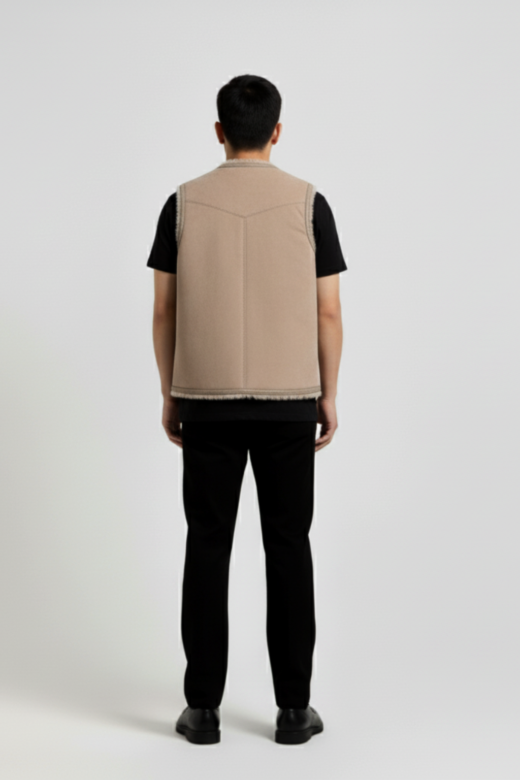 Rear view of male model wearing Maverick Owen shearling vest showing structured shoulder fit and clean back styling. Maverick Jacket.