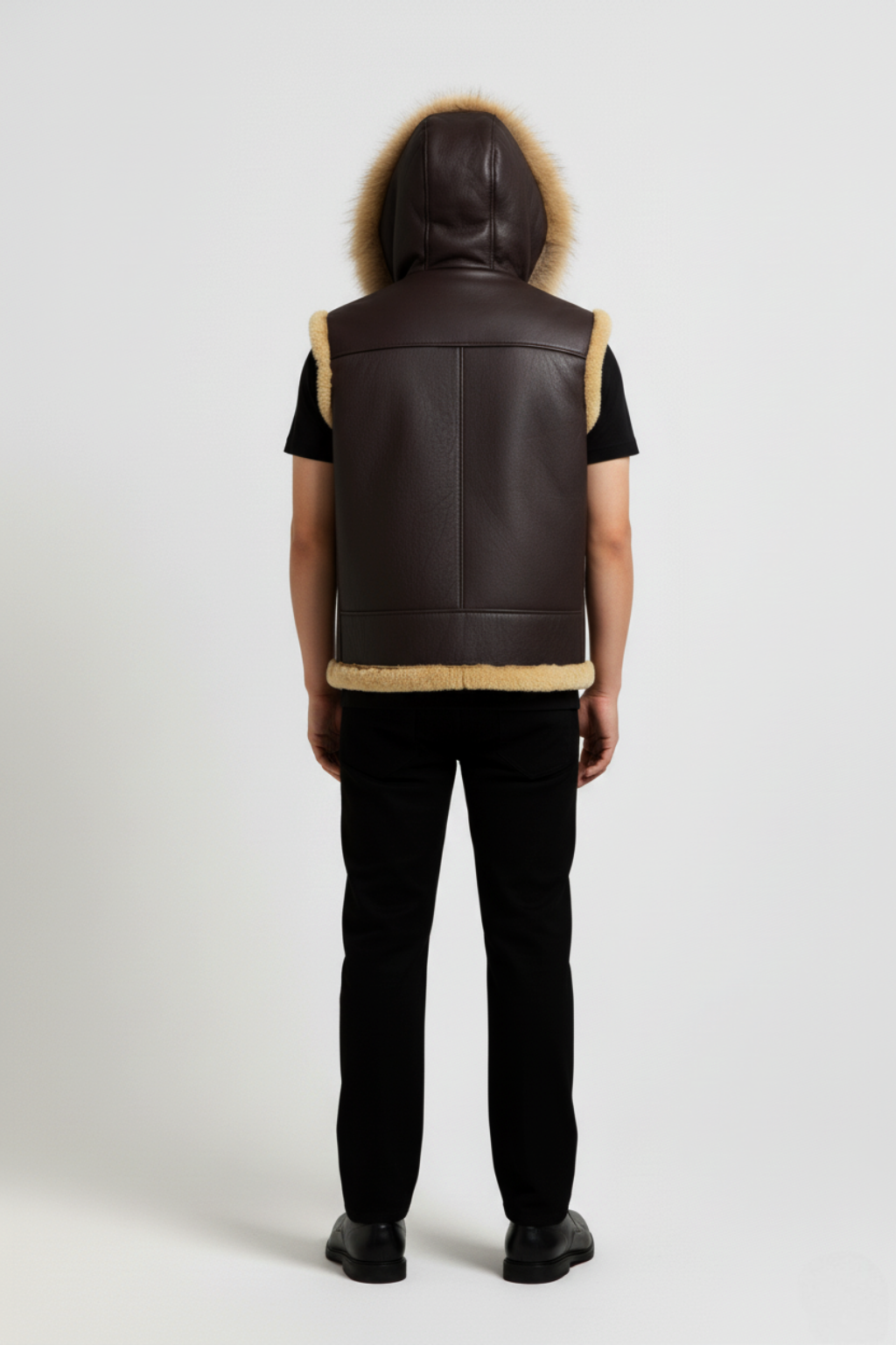 Rear view of male model wearing Maverick Magnus hooded shearling vest showing hood drape and robust shoulder fit. Maverick Jacket.