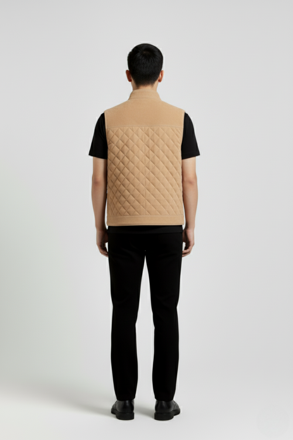 Rear view of male model wearing Maverick Leo suede quilted vest showing broad shoulder fit and clean back styling. Maverick Jacket.