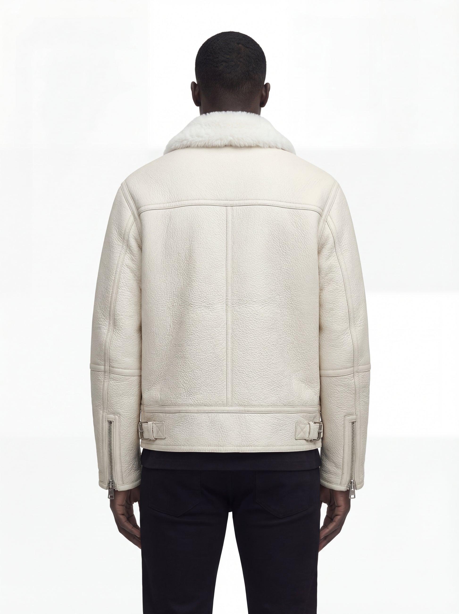 Rear view of male model wearing Maverick Summit shearling jacket showing structured shoulder fit and buckle-tab hem styling. Maverick Jacket.