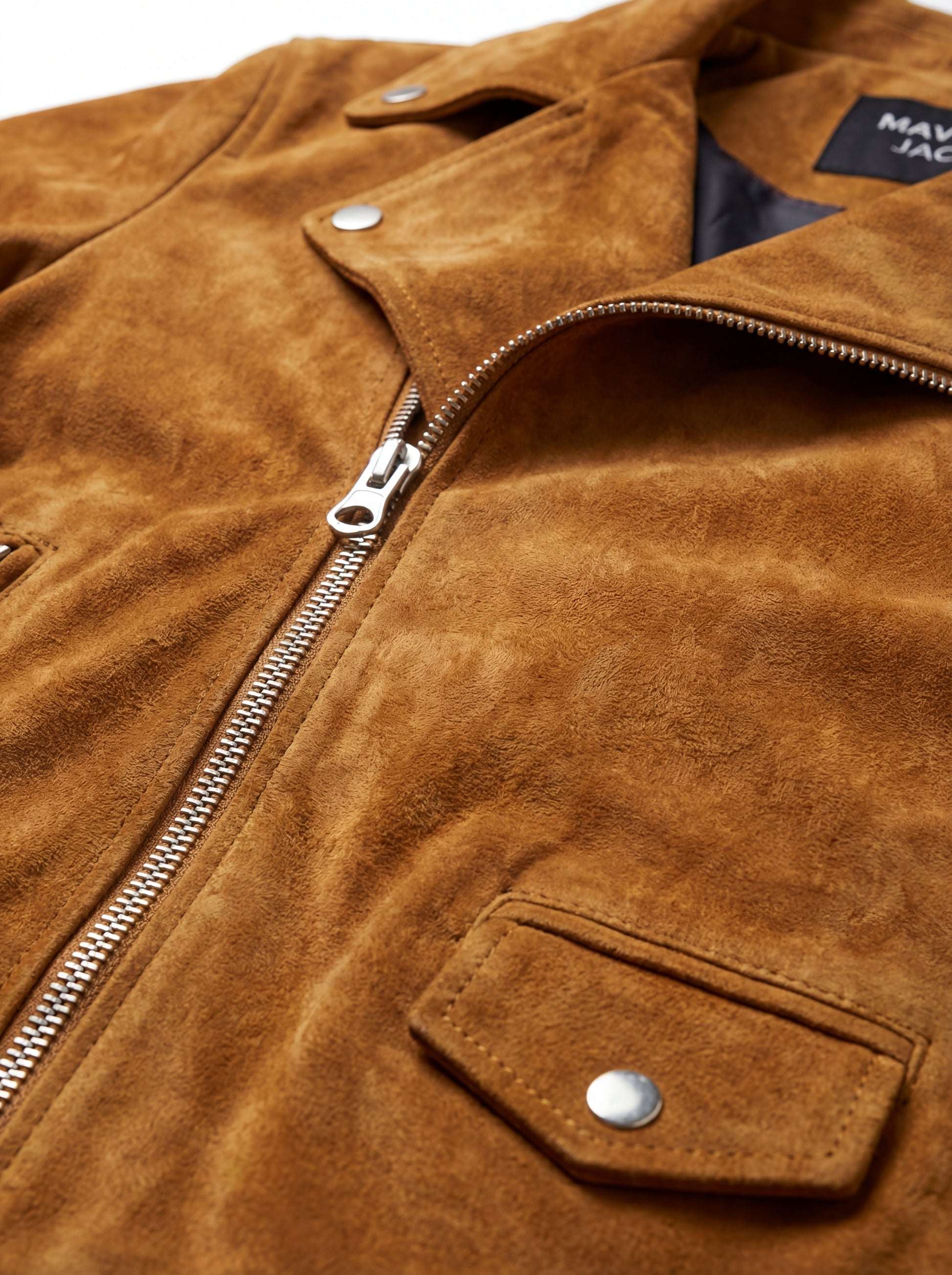 Macro shot of soft tan suede texture and silver zipper hardware on biker jacket. The Atlas by Maverick Jacket.